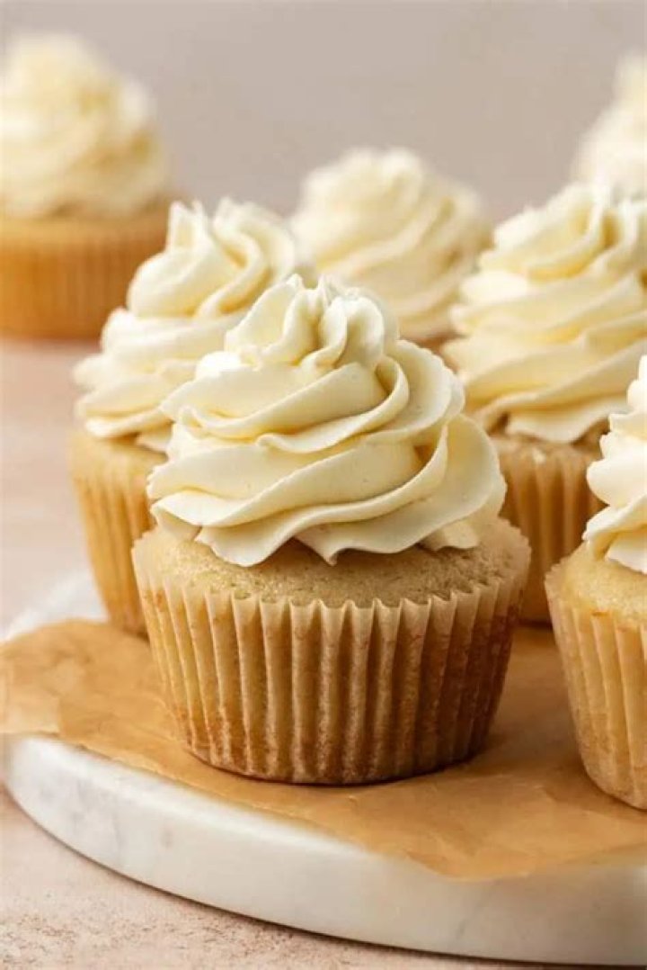 Small batch vanilla cupcakes topped with white frosting and rainbow sprinkles.